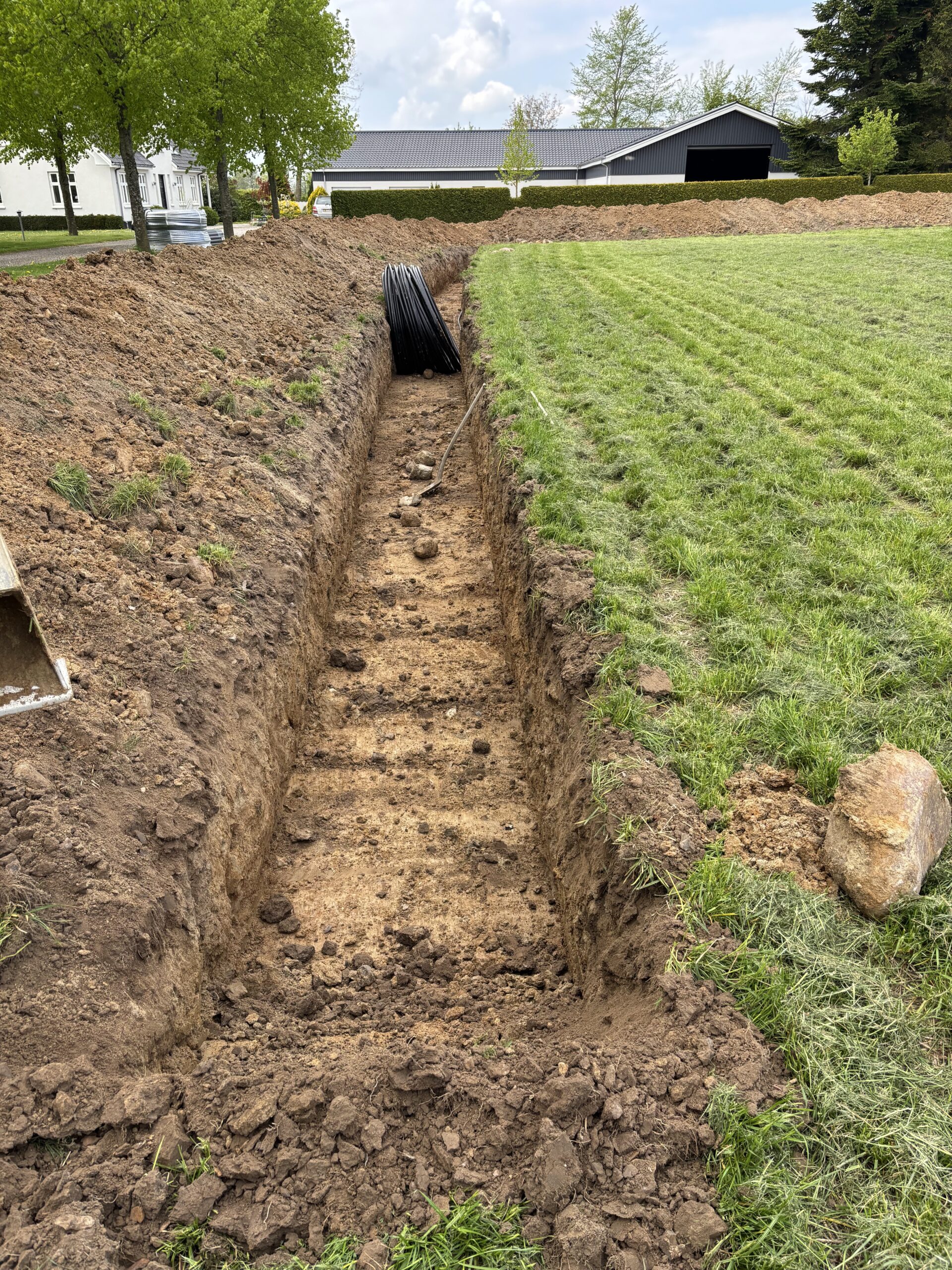 Forberedelse til støttemur og beplantning i have med jordarbejde